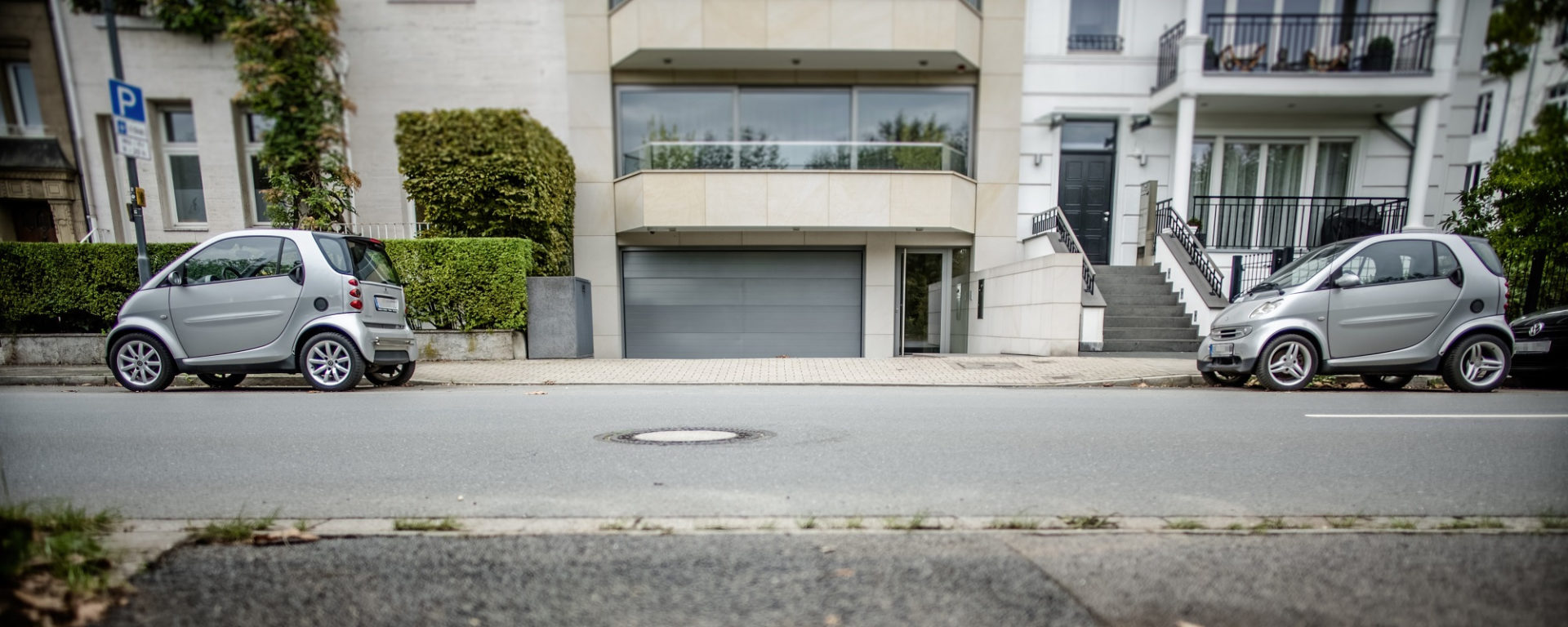 Zwei Autos als Poller: In einer der besten Wohnlagen Düsseldorfs sichern die beiden Smarts die ausreichend breite Zufahrt zur Tiefgarage. Foto: Andreas Endermann