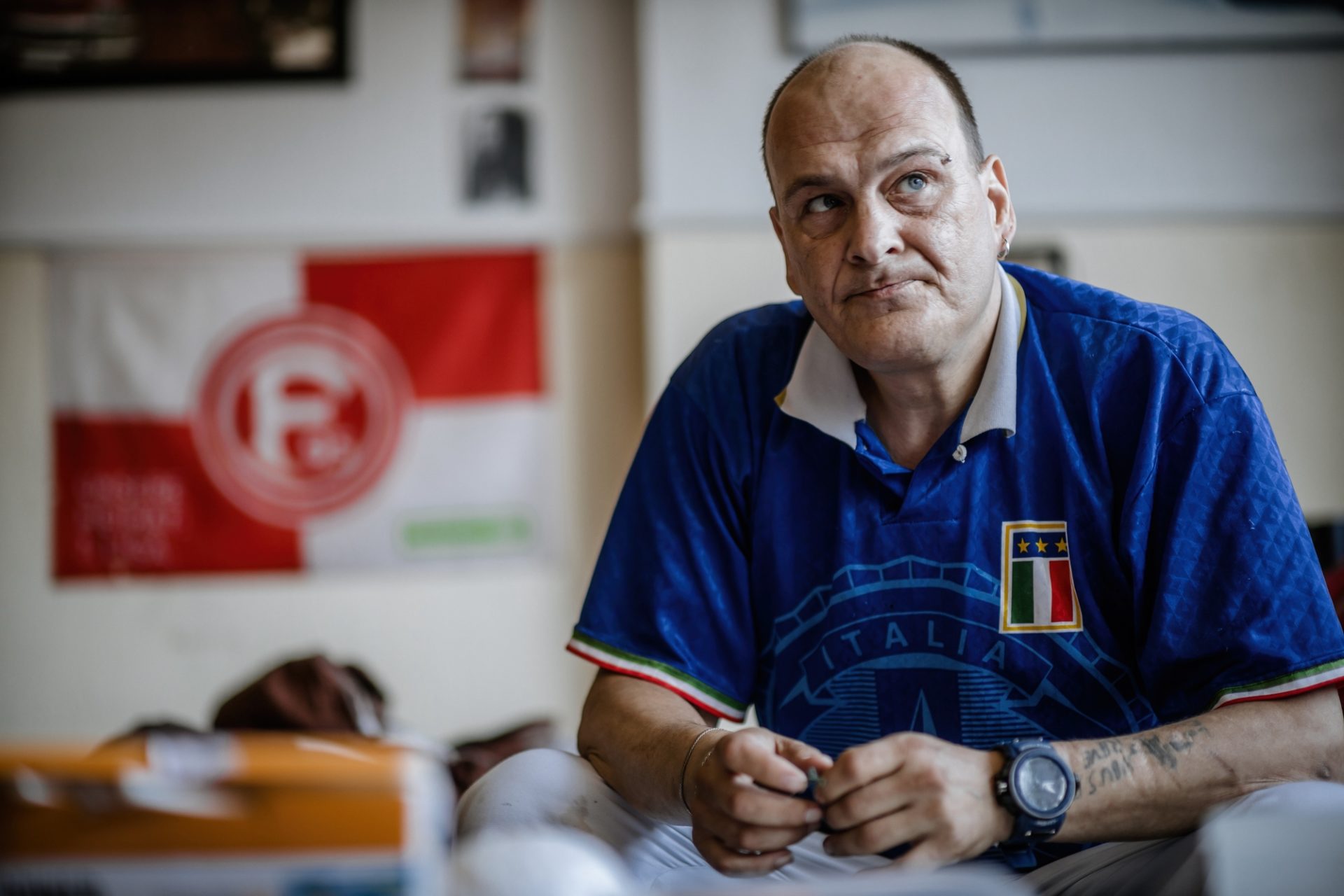 Andre in seiner Wohnung, die er durch das Projekt "Housing first" bekommen hat. Er ist Fortuna-Sympathisant, sagt er. Dortmund ist aber gut. Foto: Andreas Endermann