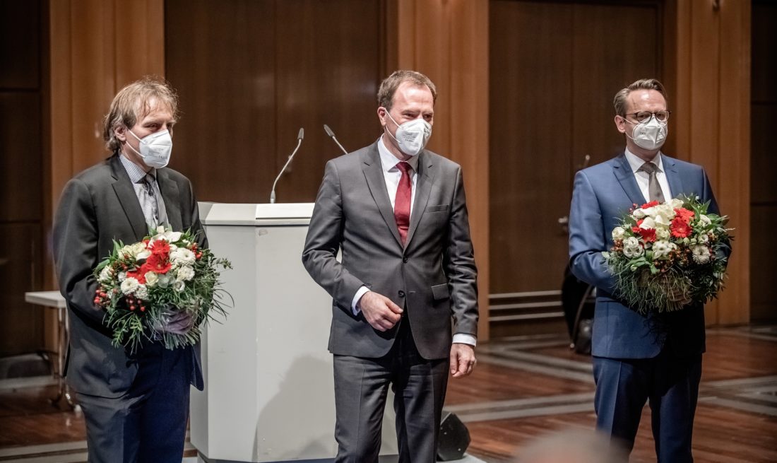 Wie so oft: Zwei Männer (Jochen Kral, links, und Michael Rauterkus, rechts) erhalten nach ihrer Wahl zu Beigeordneten Blumensträuße vom Oberbürgermeister (Stephan Keller). Foto: Andreas Endermann