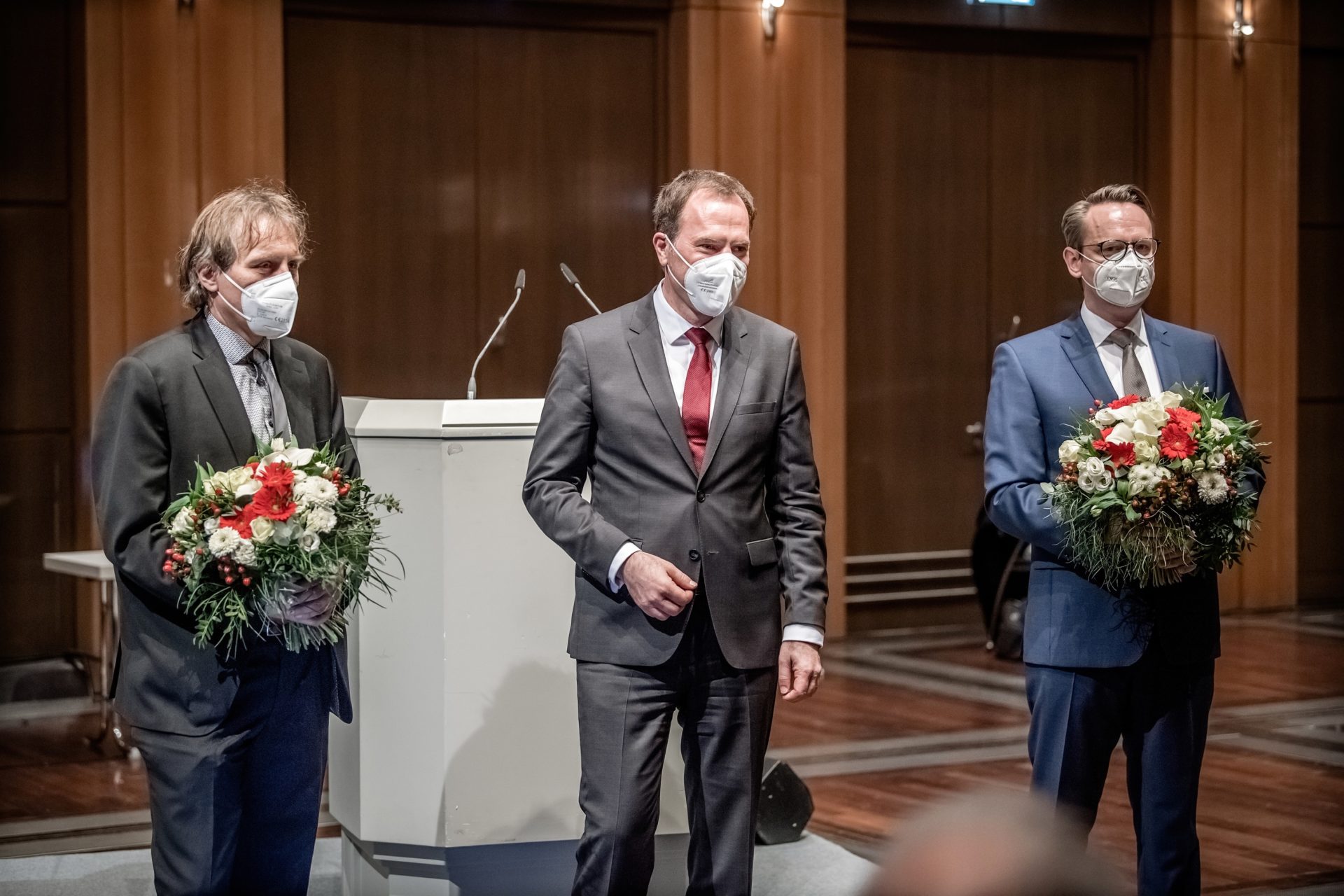 Wie so oft: Zwei Männer (Jochen Kral, links, und Michael Rauterkus, rechts) erhalten nach ihrer Wahl zu Beigeordneten Blumensträuße vom Oberbürgermeister (Stephan Keller). Foto: Andreas Endermann